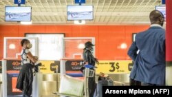 FILE: Travelers wearing protective face masks at the Ndjili airport in Kinshasa, DRC on August 15, 2020, as travel restrictions due to the COVID-19 pandemic are lifted. 
