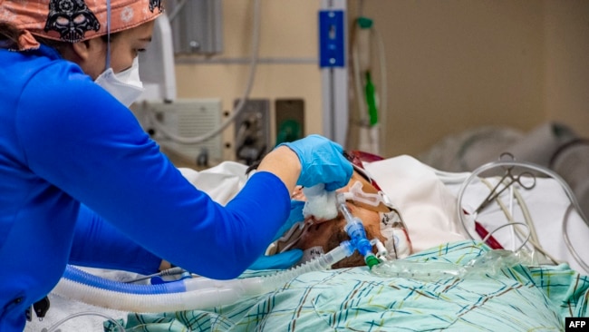 FILE - A medical worker treats an unvaccinated 40 year old patient who is suffering from the effects of Covid-19 in the ICU at Hartford Hospital in Hartford, Connecticut on January 18, 2022. (Photo by Joseph Prezioso / AFP)