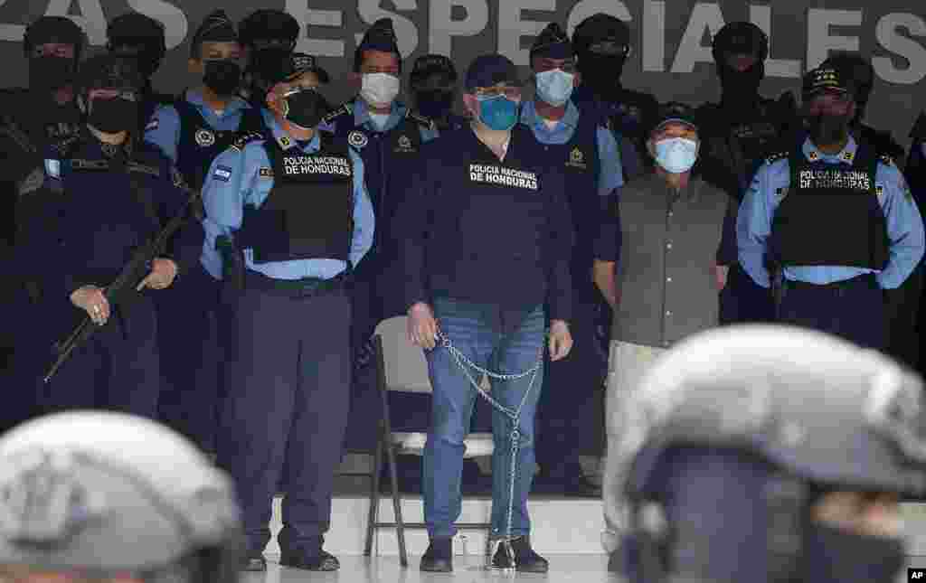 Former Honduran President Juan Orlando Hernandez, center in chains, is shown to the press at&nbsp; Police Headquarters in Tegucigalpa, Honduras, Feb. 15, 2022. Police arrested Hernandez at his home following a request by the U.S. government for his extradition on drug trafficking and weapons charges.