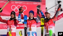 From left, Johannes Strolz, of Austria, silver, Clement Noel, of France, gold, and Sebastian Foss-Solevaag, of Norway, bronze, celebrate after the medal ceremony for the men's slalom at the 2022 Winter Olympics, Feb. 16, 2022.