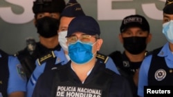 El expresidente de Honduras, Juan Orlando Hernández, observa a las Fuerzas Especiales de la Policía luego de ser detenido por miembros de la Policía Nacional de Honduras en Tegucigalpa, Honduras, el 15 de febrero de 2022.