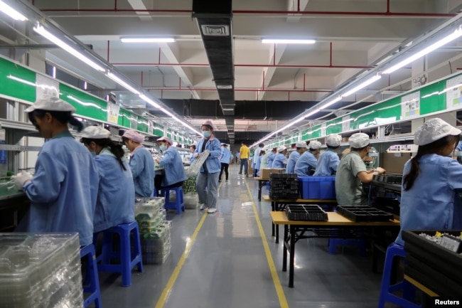 资料照：中国广东东莞一家生产移动游戏控制器的工厂工人在生产线上工作。（2021年12月7日）