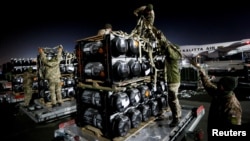 FILE - Ukrainian service members unpack Javelin anti-tank missiles, delivered by plane as part of the US military support package for Ukraine, at the Boryspil International Airport outside Kyiv, Ukraine, Feb. 10, 2022. 