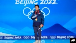 美国滑冰运动员陈巍（Nathan Chen）在北京冬奥会获取花样滑冰男单自由滑金牌时手置前胸聆听国歌。（2022年2月10日）