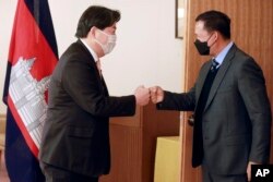 Japanese Foreign Minister Yoshimasa Hayashi, left, greets with Hun Manet, Commander of the Royal Cambodian Army in Tokyo, Monday, Feb. 14, 2022. (AP Photo/Koji Sasahara)