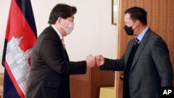 Japanese Foreign Minister Yoshimasa Hayashi, left, greets with Hun Manet, Commander of the Royal Cambodian Army in Tokyo, Monday, Feb. 14, 2022. (AP Photo/Koji Sasahara)
