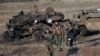 FILE - Russia-backed separatists walk after inspecting destroyed Ukrainian army tanks near Lohvynove, Ukraine, Feb. 22, 2015. A peace accord for eastern Ukraine has remained stalled for years, but it has come into the spotlight again amid a Russian military buildup near Ukraine.