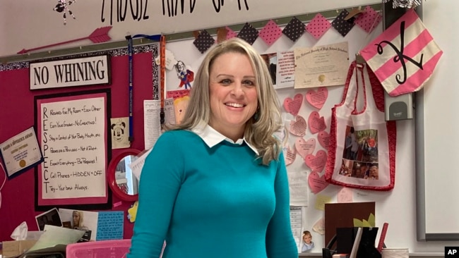 Katie Peters, an English teacher at Whitmer High School, poses in her classroom on Feb. 7, 2022, in Toledo, Ohio. (AP Photo/John Seewer)