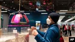 Canadian technician Matthew Potvin reaches for his lunch delivered to him robotically in the dining area of the main media center at the 2022 Winter Olympics, Monday, Jan. 24, 2022, in Beijing. (AP Photo/Jae C. Hong)