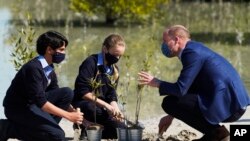 Pangeran William dari Inggris berbicara dengan siswa Sekolah Inggris Al-Khubairat Amaan Haider (kiri), dan Lilly-Rose Mayall, di Taman Mangrove Al-Jubail di Abu Dhabi, Uni Emirat Arab, Kamis, 10 Februari 2022. (AP/Jon Gambrell)