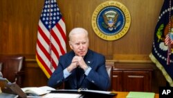 This image provided by The White House via Twitter shows President Joe Biden at Camp David, Md., Saturday, Feb. 12, 2022. Biden on Saturday again called on President Vladimir Putin to pull back more than 100,000 Russian troops massed near Ukraine’s border