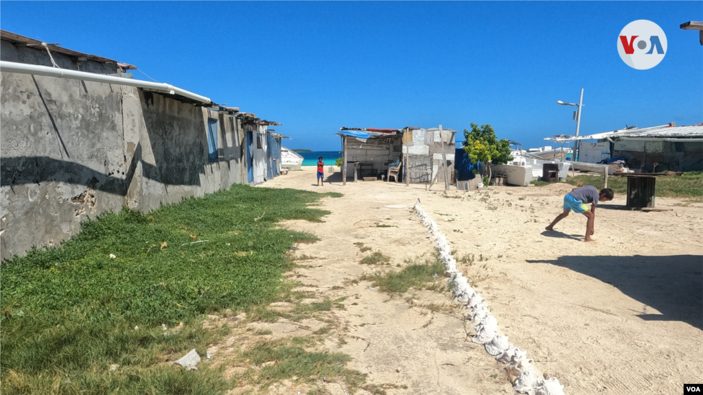 Dos chicos juegan a la pelota cerca de las casas de los pobladores en Cayo Pirata.&nbsp;