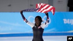 Erin Jackson moun peyi Etazini vole drapo Ameriken an apre li pran meday lo a nan konpetisyon 500 met patinaj vites la nan Jezolenpik Ive Peken yo, Dimanch 13 Fevriye 2022. 
