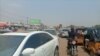 A motorcyclist passing through vehicles in traffic caused by fuel queues in Abuja Nigeria, Feb. 16, 2022.