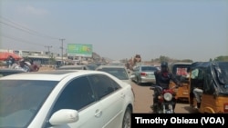 A motorcyclist passing through vehicles in traffic caused by fuel queues in Abuja Nigeria, Feb. 16, 2022.