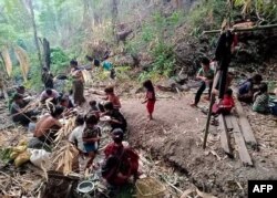 This handout photo from local media group Chin World taken in May 2021 and released on May 20, 2021, shows displaced people from Mindat taking shelter in a forest in western Myanmar's Chin state, amid ongoing attacks by the military following clashes with the Chinland Defence Force (CDF) militia group.