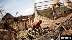 FILE - A man works on the destroyed house of Philibert Jean Claude Razananoro, in the aftermath of Cyclone Batsirai, in the town of Mananjary, Madagascar, Feb. 8, 2022. 