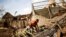 FILE - A man works on the destroyed house of Philibert Jean Claude Razananoro, in the aftermath of Cyclone Batsirai, in the town of Mananjary, Madagascar, Feb. 8, 2022. 