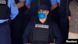 El expresidente hondureño Juan Orlando Hernández junto a oficiales de la policía luego de ser detenido por miembros de la Policía Nacional de Honduras, en Tegucigalpa, Honduras, el 15 de febrero de 2022.