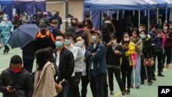 People queue to get tested for the coronavirus at a makeshift testing site in Hong Kong, Feb. 10, 2022.