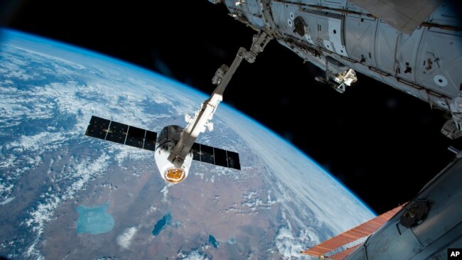 In this Friday, April 17, 2015 file photo, the Canadarm 2 reaches out to capture the SpaceX Dragon cargo spacecraft for docking to the International Space Station. (AP Photo/NASA)