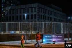 People pass by the closed US embassy in Kyiv after operations were moved to Lviv, Feb. 14, 2022.
