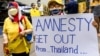 FILE - A royalist supporter holds a sign during a demonstration in Bangkok on November 25, 2021, calling for the human rights organization Amnesty International to stop operations in Thailand.