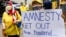 FILE - A royalist supporter holds a sign during a demonstration in Bangkok on November 25, 2021, calling for the human rights organization Amnesty International to stop operations in Thailand.