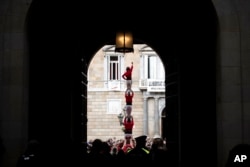 Participants in the "diada Castellera'' try to complete a human tower during the Saint Eulàlia celebrations in Barcelona, Spain, Feb. 11, 2022.