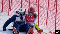 A team member consoles Mikaela Shiffrin, of the United States after she skied out in the first run of the women's slalom at the 2022 Winter Olympics, Feb. 9, 2022.