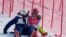 A team member consoles Mikaela Shiffrin, of the United States after she skied out in the first run of the women's slalom at the 2022 Winter Olympics, Feb. 9, 2022.