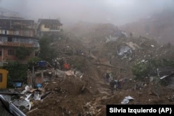 Rescue workers and residents look for victims in an area damaged by landslides in Petropolis, Brazil, Wednesday, Feb. 16, 2022.