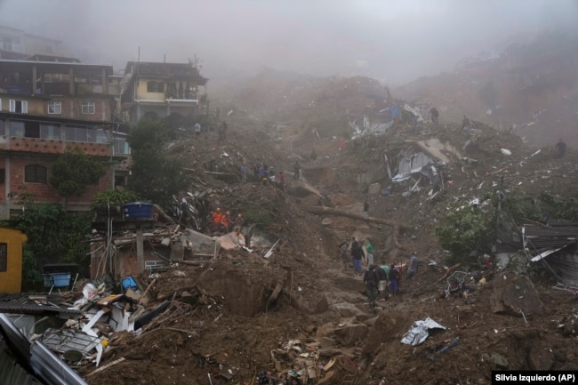 Rescue workers and residents look for victims in an area damaged by landslides in Petropolis, Brazil, Wednesday, Feb. 16, 2022.