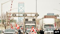 Pendukung Konvoi Pengemudi Truk menentang mandat vaksin COVID-19, memblokir lalu lintas di jalur lintas perbatasan Jembatan Duta Besar Kanada, di Windsor, Ontario, 8 Februari 2022. (Geoff Robins / AFP)