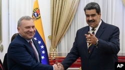 El viceprimer ministro de Rusia, Yuri Borisov, a la izquierda, y el presidente de Venezuela, Nicolás Maduro, se dan la mano durante una presentación ante los medios en el Palacio Presidencial en Caracas, Venezuela, el 16 de febrero de 2022.