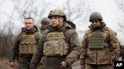 Ukrainian President Volodymyr Zelenskiy, center, surrounded by servicemen as he visits the war-hit Donetsk region, eastern Ukraine, Thursday, Feb. 11, 2021. (Ukrainian Presidential Press Office via AP)