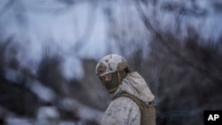 A Ukrainian serviceman provides area security during a visit by Gen. Oleksandr Pavliuk, commander of the Joint Forces Operation, to frontline positions outside Avdiivka, Donetsk region, eastern Ukraine, Feb. 9, 2022. 