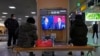 韩国民众在首尔火车站观看两位总统候选人的电视辩论直播。（2022年2月3日）