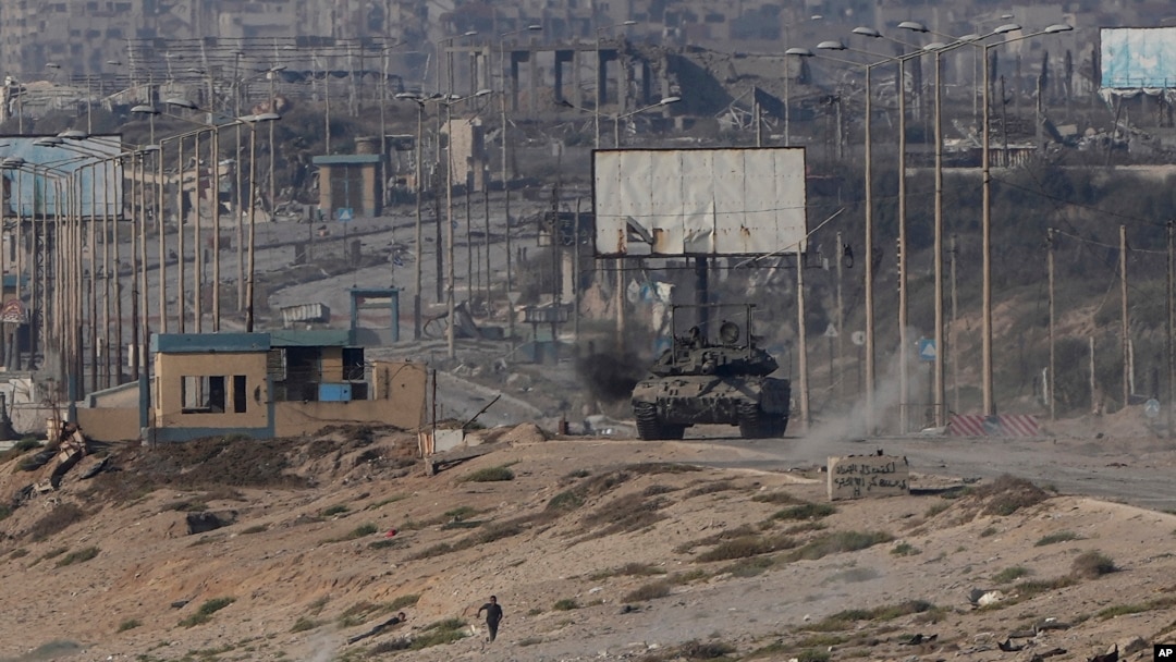Seorang warga Palestina melarikan diri dari tank Israel di Jalur Gaza tengah pada Minggu, 9 Juni 2024. (Foto: AP)