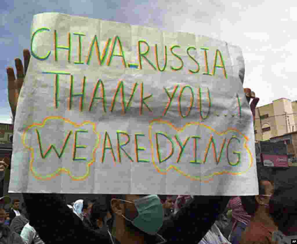 A protester holds a banner during a demonstration after Friday prayers in the Syrian port city of Banias April 29, 2011. (Reuters image)