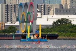Athletes compete in the swim leg of the men's individual triathlon at the 2020 Summer Olympics, in Tokyo, Japan, July 26, 2021.