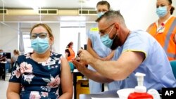 FILE - Nurse manager Sue McGrady receives the Pfizer COVID-19 vaccine at the Royal Prince Alfred Hospital Vaccination Hub in Sydney, Australia, Feb. 22, 2021.