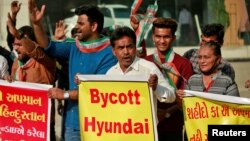 Demonstrators shout slogans in front of a Hyundai showroom during a protest against a tweet from the account of Hyundai Pakistan partner that expressed solidarity for the people of Kashmir, in Ahmedabad, India, Feb. 9, 2022. 