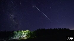 FILE - This time-exposure image shows a trail of a group of SpaceX's Starlink satellites passing over Uruguay, some 185 km north of Montevideo, Feb. 6, 2021. Up to 40 SpaceX high-speed internet satellites were knocked out of orbit by a geomagnetic storm s