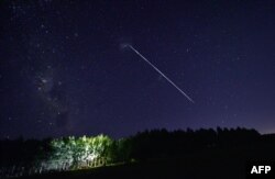 FILE - This time exposure image shows a trace of a group of SpaceX's Starlink satellites passing over Uruguay, approximately 185 km north of Montevideo, on February 6, 2021. Up to 40 SpaceX high-speed Internet satellites were knocked out of orbit by a geomagnetic storm shortly after. the launch.