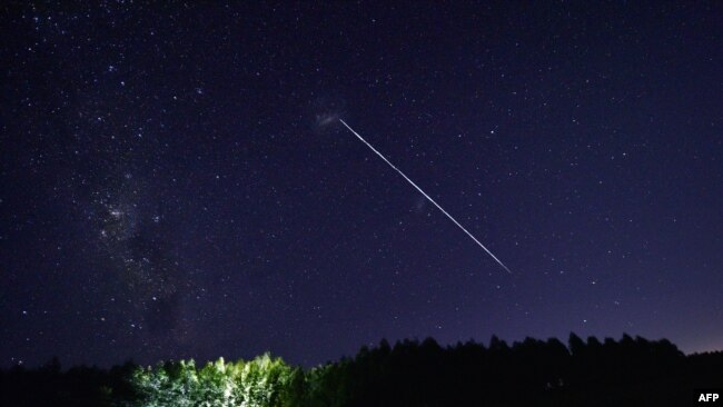 FILE - This time-exposure image shows a path of a group of SpaceX's Starlink satellites passing over Uruguay, some 185 km north of Montevideo on February 6, 2021. Up to 40 SpaceX high-speed internet satellites were pushed out of orbit by a geomagnetic storm shortly after launch. (Photo by Mariana SUAREZ / AFP)