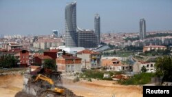 An excavator demolishes a house at the construction site in Istanbul. Turkey, August 14, 2014. 