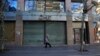 A woman passes a shuttered cosmetic shop on Hamra Street, Beirut, January 12, 2022. (Hussein Malla/AP)