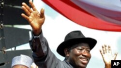 Shugaba Goodluck Jonathan na Nigeria ne yake daga wa taron jama'a hannu kafin kaddamarda gangamin kyamfen dinsa na neman zabe a Abuja, Nigeria.