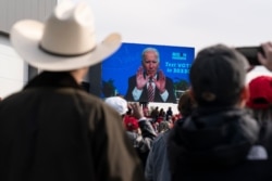 Supporters watch a video as President Donald Trump speaks at a campaign rally at Manchester-Boston Regional Airport, Oct. 25, 2020, in Londonderry, N.H.